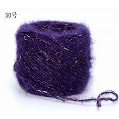 a purple ball of yarn sitting on top of a white table next to a string