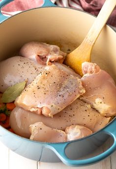 a pot filled with chicken and carrots on top of a table