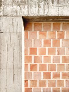 a red fire hydrant sitting next to a wall with a brick pattern on it