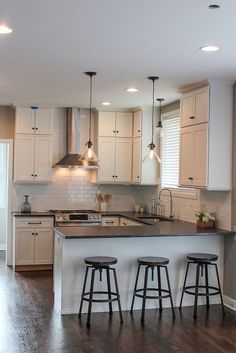 a kitchen with white cabinets and wooden floors