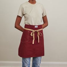 a woman in an apron stands with her hands on her hips