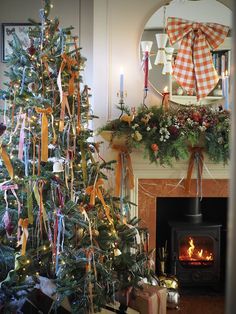 a decorated christmas tree sitting in front of a fire place