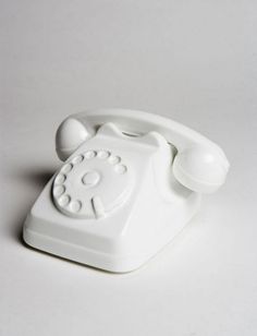 an old fashioned white telephone on a white surface