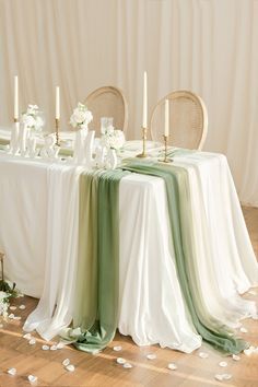 the table is set with white flowers and candles