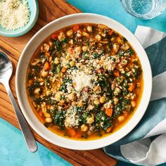 a bowl of soup with spinach, chickpeas and parmesan cheese