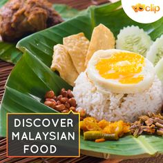 a plate with rice, meat and vegetables on it next to some banana leaf leaves