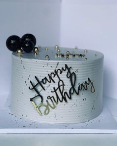 a birthday cake with the words happy birthday written in black and gold letters on it