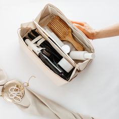 a woman's hand is holding a bag full of personal care items