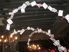 a group of people sitting at tables with cards on the ceiling and chandeliers hanging from the ceiling