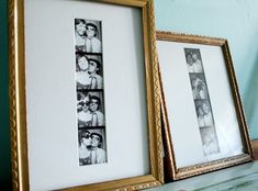 two framed pictures sitting next to each other on top of a table in front of a wall