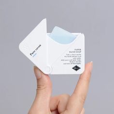 a person holding up a small white object in their hand