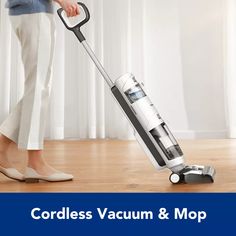 the cordless vacuum & mop is on display in front of a woman's legs