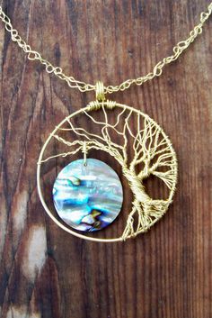 a necklace with a tree on it sitting on top of a wooden table