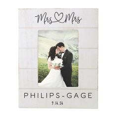 a white wooden frame with the words mrs and mr on it, holding a bouquet of flowers