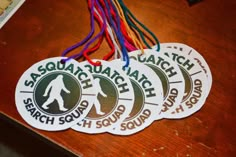 four stickers with the words sasquada squatch on them sitting on a table