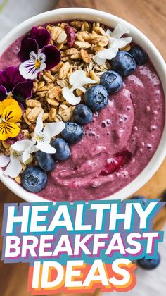 a bowl filled with blueberries and granola on top of a wooden table