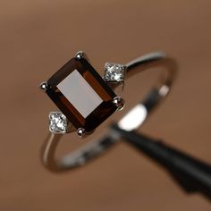 a brown and white diamond ring sitting on top of a table