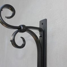 an iron hook on the side of a white wall