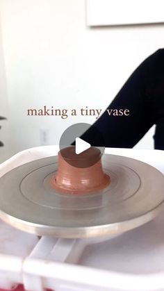 a woman making a tiny vase out of clay