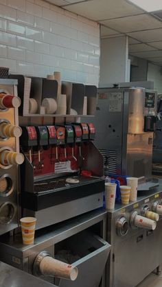 an industrial kitchen with coffee machines and cups on the counter, along with other items