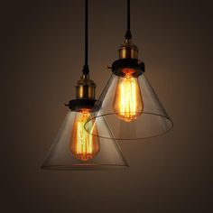 three light bulbs hanging from the ceiling in an industrial style setting with clear glass shades