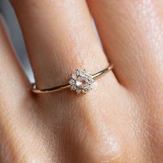 a woman's hand with a diamond ring on top of her finger and the other hand holding it