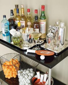 an assortment of liquor bottles and glasses on a bar cart with drinks in buckets