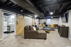 a living room filled with furniture and a flat screen tv mounted to the wall above it