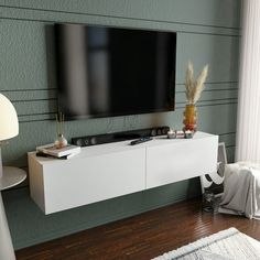 a flat screen tv mounted to the side of a white entertainment center in a living room