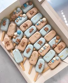 a box filled with lots of cookies on top of wooden sticks in the shape of animals