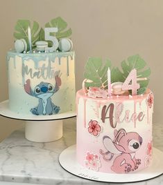 two birthday cakes decorated with cartoon characters on top of marble counter tops, one is pink and the other is blue