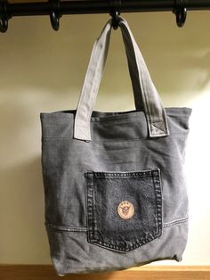 a gray bag hanging from a metal hook