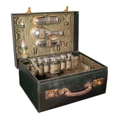 an old suitcase filled with lots of bottles and silverware on top of a white background