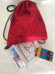 a drawstring bag with spider - man on it and some other items next to it