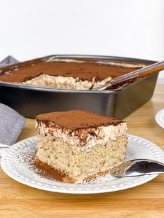 a piece of cake sitting on top of a white plate next to a metal pan