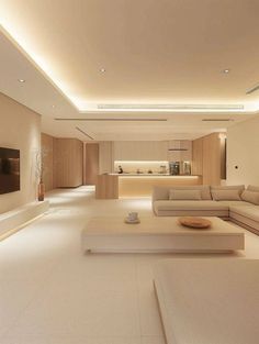 a large living room with white furniture and lighting on the ceiling is lit by recessed lights