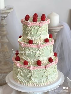 a three tiered cake with raspberries on the top and bottom is decorated in pastel colors