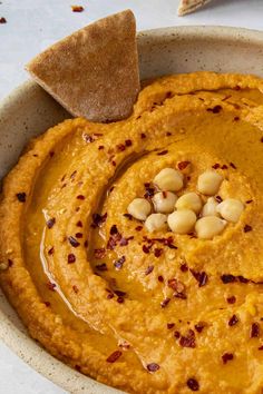 a bowl filled with hummus and some crackers