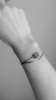 a black and white photo of a wrist tattoo