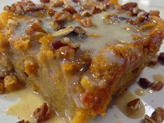 a close up of a piece of cake on a plate with pecans around it