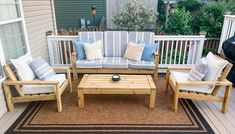 a patio with wooden furniture and pillows on it