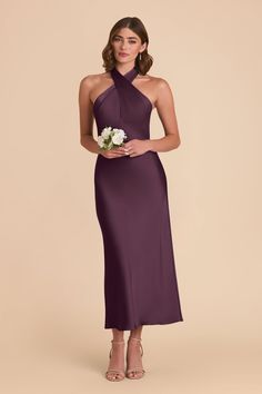 a woman in a long purple dress holding a flower