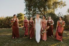 a group of women standing next to each other on top of a lush green field