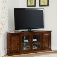 a flat screen tv sitting on top of a wooden entertainment center in a living room