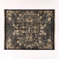 an old rug with flowers and leaves on the bottom is shown in black, beige, and white colors