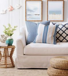 a living room filled with furniture and pictures on the wall next to a table full of flowers