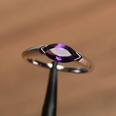 a ring with a purple stone on it