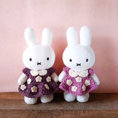 two stuffed animals are dressed in crocheted clothing and standing next to each other