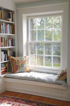 a window seat in front of a book shelf filled with books