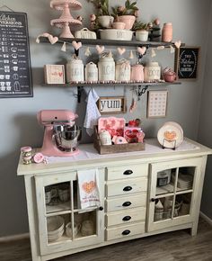 an old dresser is decorated with pink and white decor